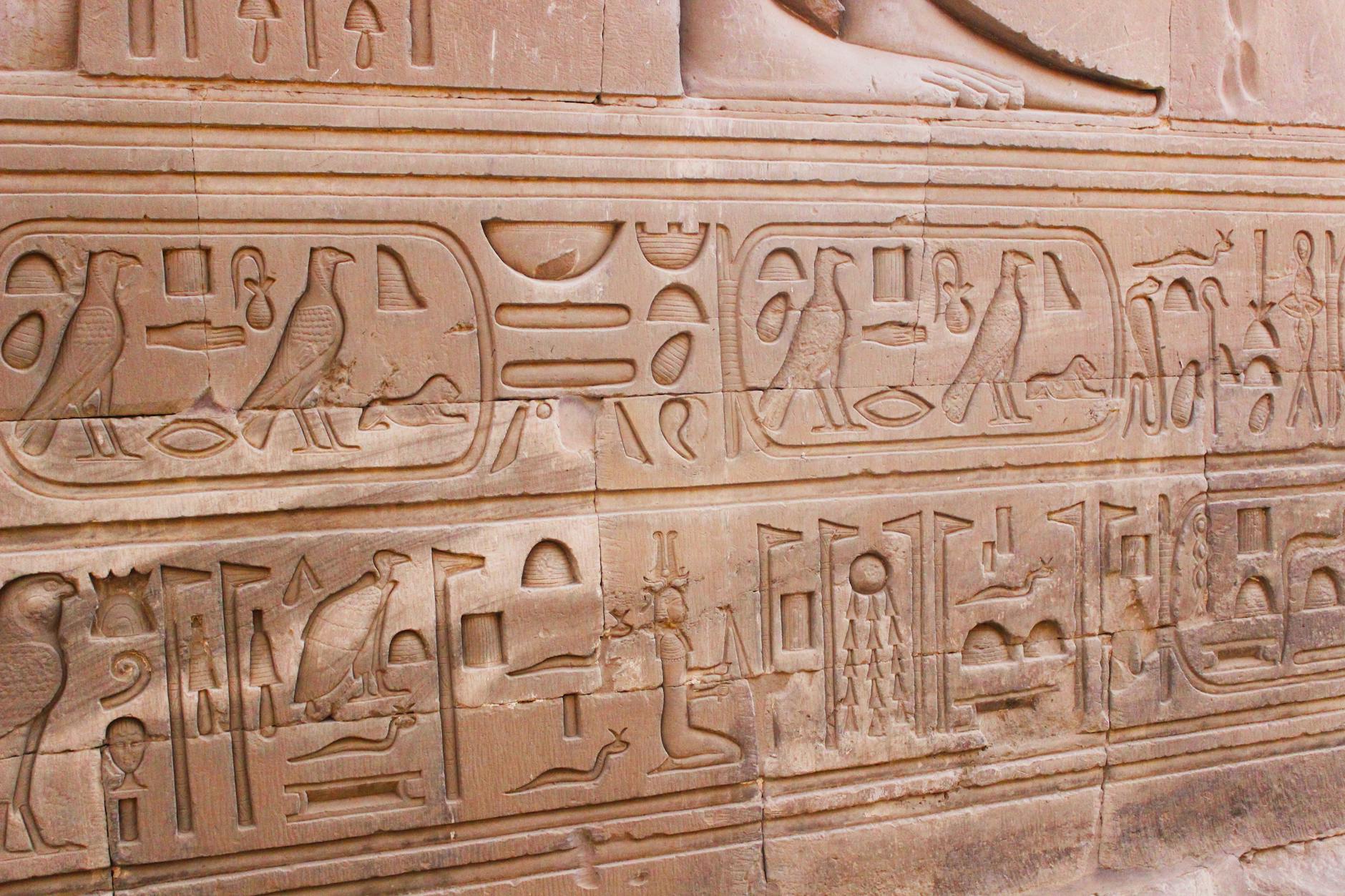 Pyramids of Giza Complete Visitor Guide — History, Tickets, and Tips 3 Ancient Egyptian hieroglyphics carved into stone walls near the Giza pyramid complex