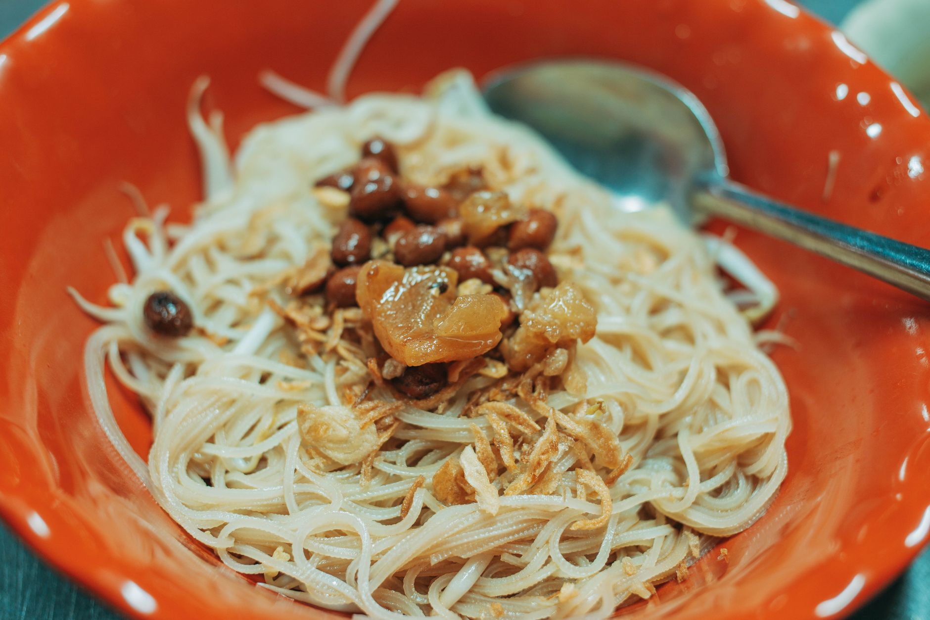 Bowl of traditional Egyptian koshari with crispy fried onions and tomato sauce at a Cairo restaurant