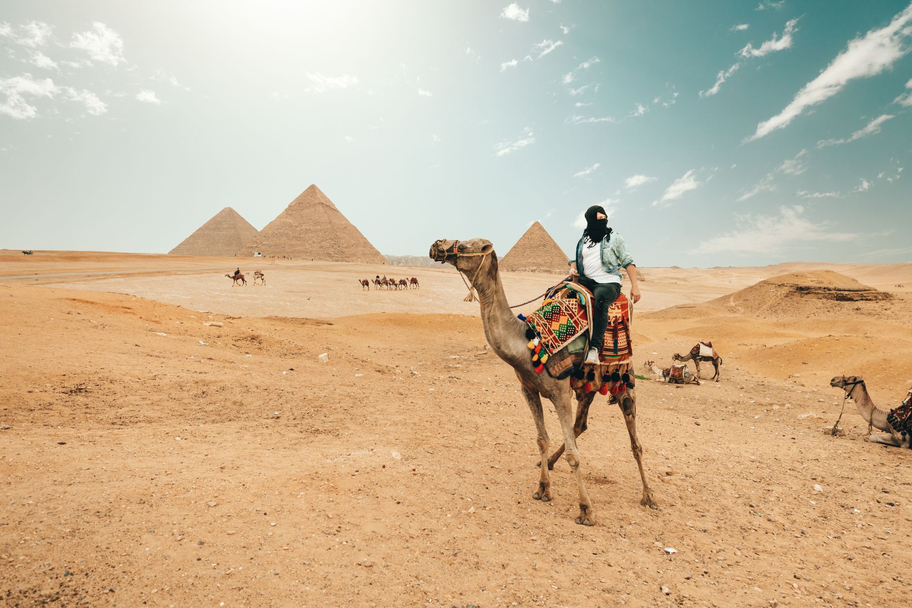 Horseback riding on the desert dunes behind the Pyramids of Giza, Cairo Egypt at golden hour