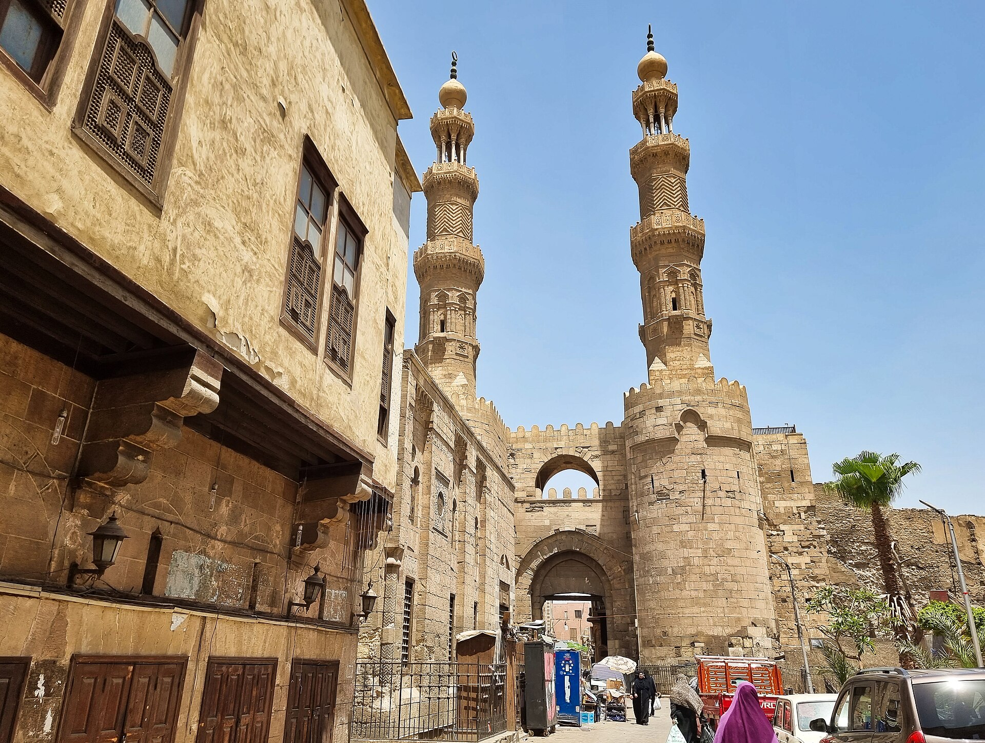 The twin minarets and round towers of Bab Zuweila, the medieval southern gate of Cairo, against a blue sky