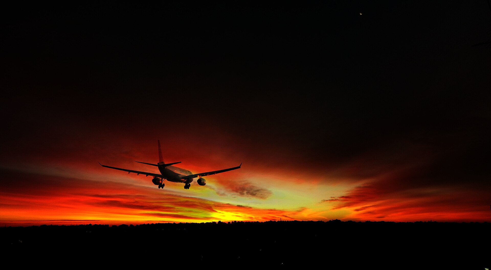 Egypt Visa on Arrival at Cairo Airport: Step by Step 2 An EgyptAir airliner silhouetted against a red sunset sky on final approach to Cairo International Airport
