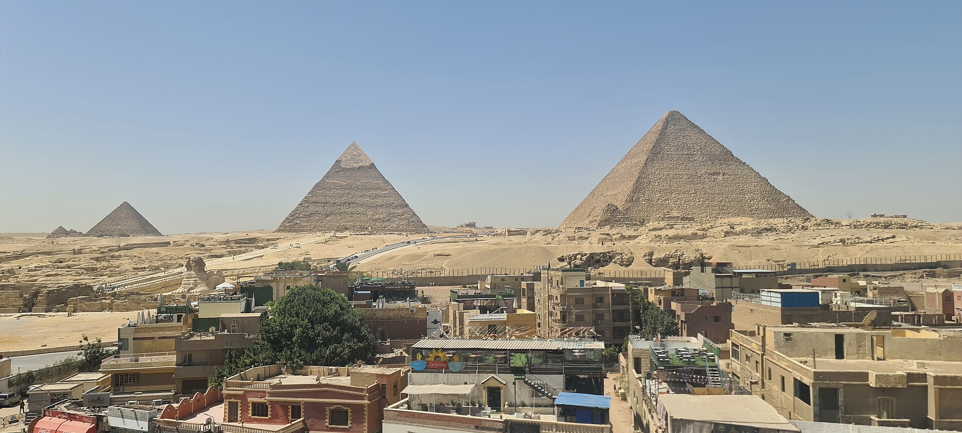 Sphinx International Airport and Cairo's Other Airports 6 The three main pyramids of Giza and the Sphinx seen above the rooftops and cafés of Nazlet el-Samman on a clear day