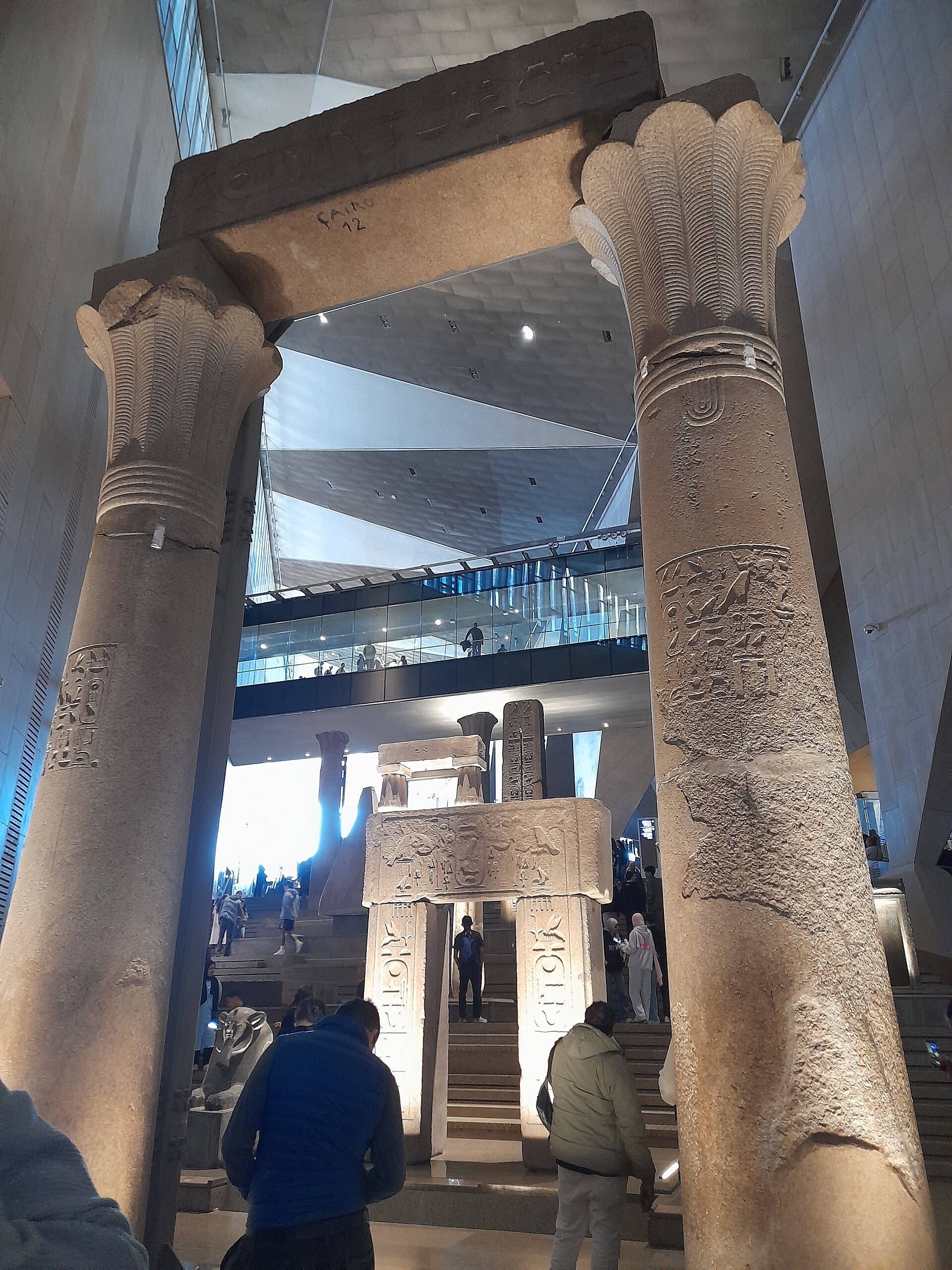 Grand Egyptian Museum and the Pyramids in One Day 4 Ancient papyrus-capital columns framing the Grand Staircase of the Grand Egyptian Museum with visitors climbing behind