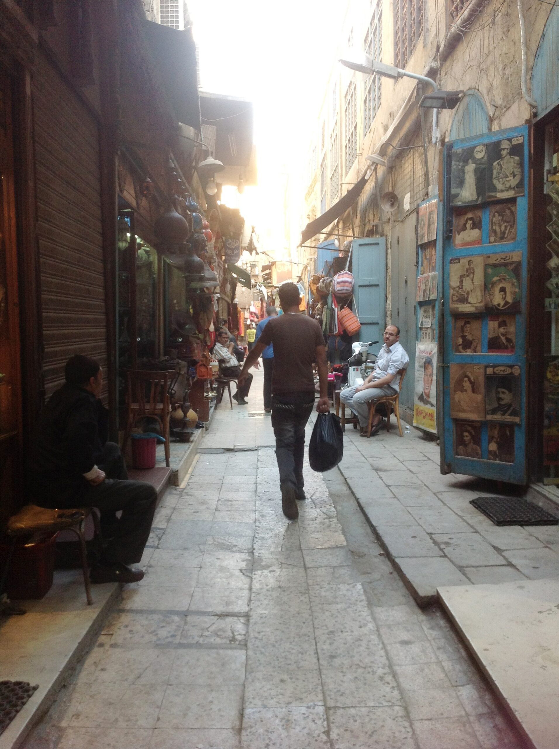 One Day in Cairo: The Perfect 24-Hour Itinerary 5 A narrow lane in Khan el-Khalili bazaar with shopkeepers seated outside and brass lanterns hanging above