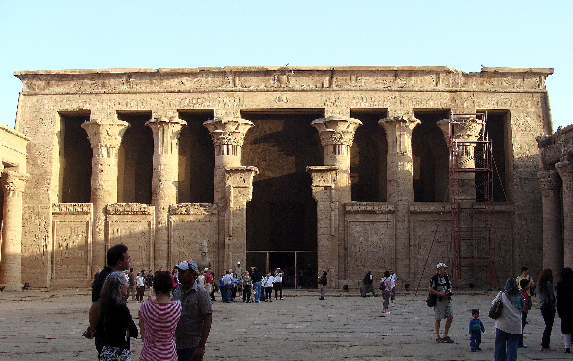 The hypostyle hall facade of the Temple of Horus at Edfu with visitors in the courtyard
